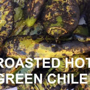 Close-up of several roasted Sandia green chile peppers with charred skins. Text overlay reads "ROASTED HOT SANDIA GREEN CHILE.