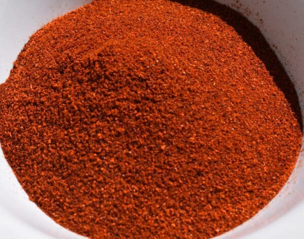 A close-up of a bowl filled with a large mound of HATCH SUN DRIED RED CHILE POWDER, CHOICE OF FLAVORS.