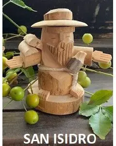 The HAND CARVED SAN ISIDRO FIGURE is a wooden sculpture of a bearded man wearing a hat, depicted with outstretched arms. He is surrounded by green berries and leaves, with the text "SAN ISIDRO" displayed below.