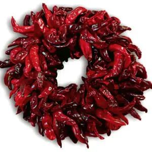 A vibrant ALL-NATURAL DRIED SANDIA CHILE PEPPER WREATH, 19 INCHES, arranged in a circular shape against a white background.