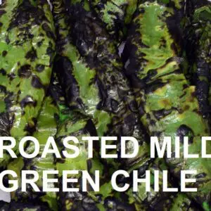 A close-up of roasted MILD-MEDIUM 6-4 green chile peppers, charred and blackened in several spots, with "ROASTED MILD-MEDIUM 6-4 GREEN CHILE" text overlaying the image.