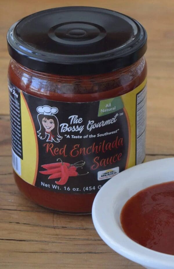 A jar of red enchilada sauce on top of a table.
