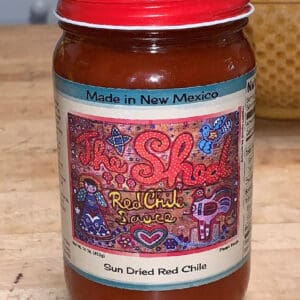 A jar of chili sauce on the table.