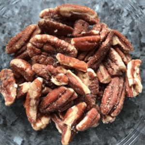 A bowl filled with shelled pecan halves.